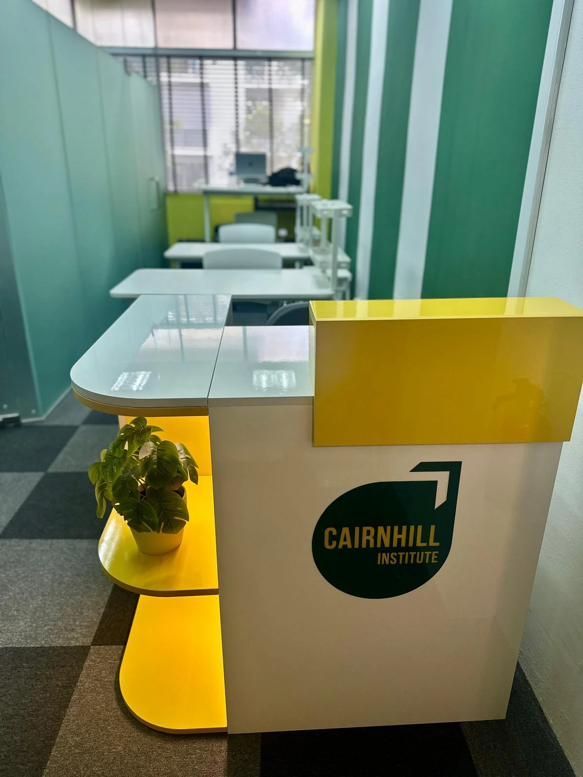 The Cairnhill reception counter on level three, with the office desks and teaching room behind it.