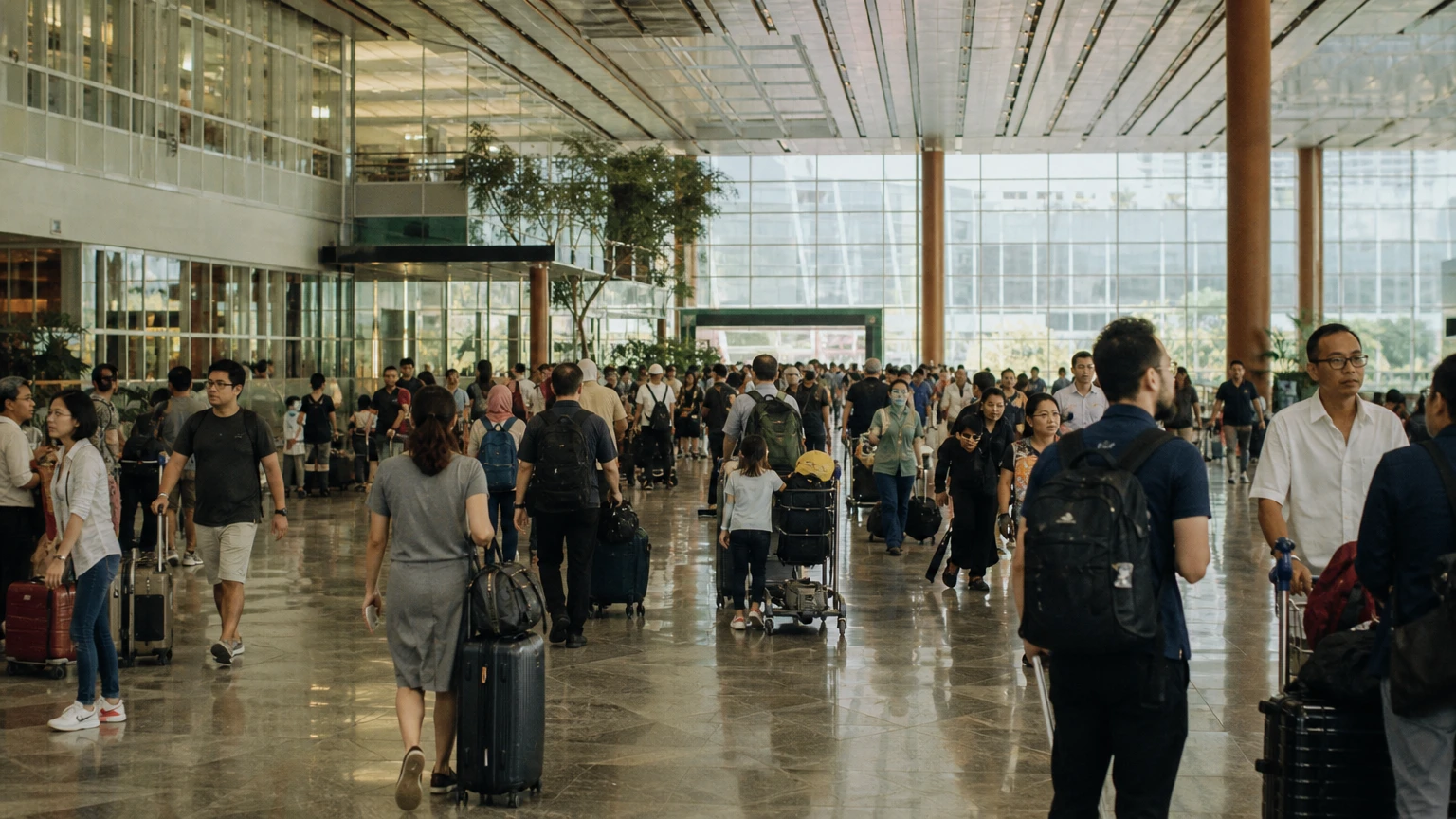 A busy arrivals hall in a Southeast Asian airport.