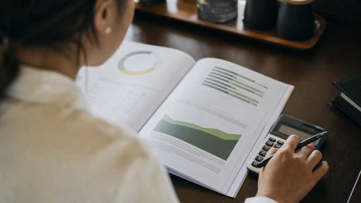 A market research report open on a desk beside a calculator.