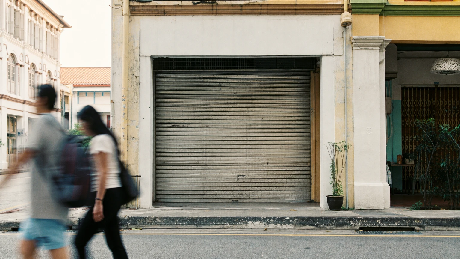 A shuttered shopfront on a Singapore street.